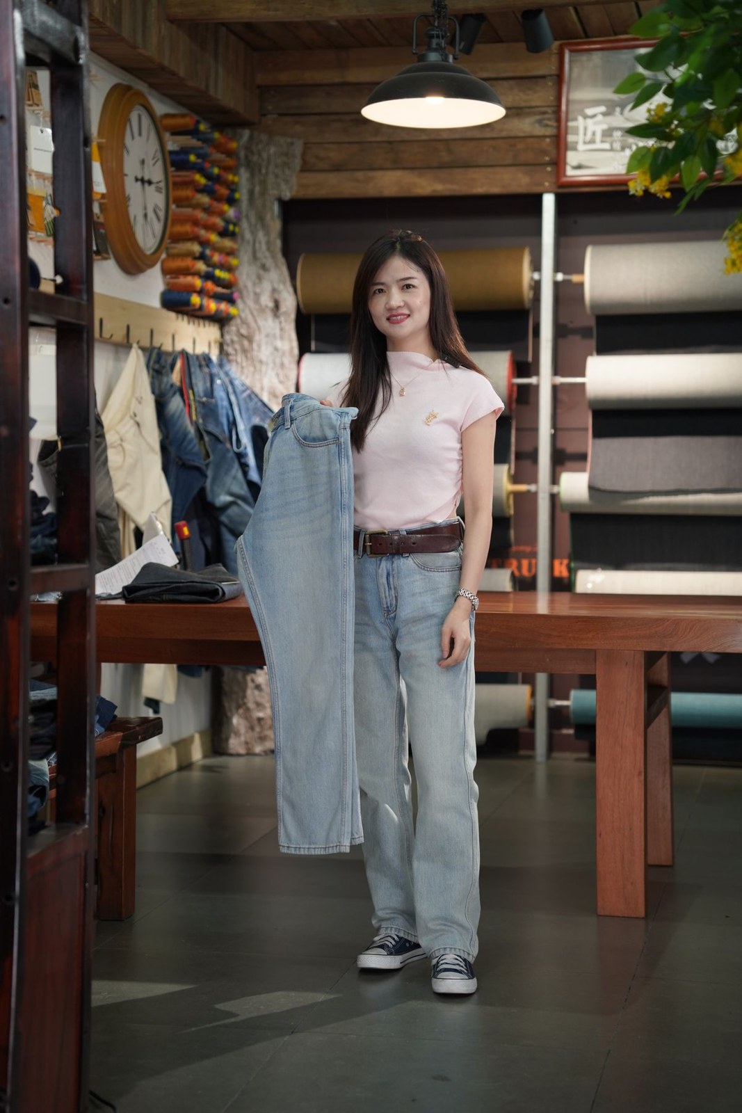 White short-sleeve T-shirt, pale straight jeans, dark belt and dark canvas trainers.