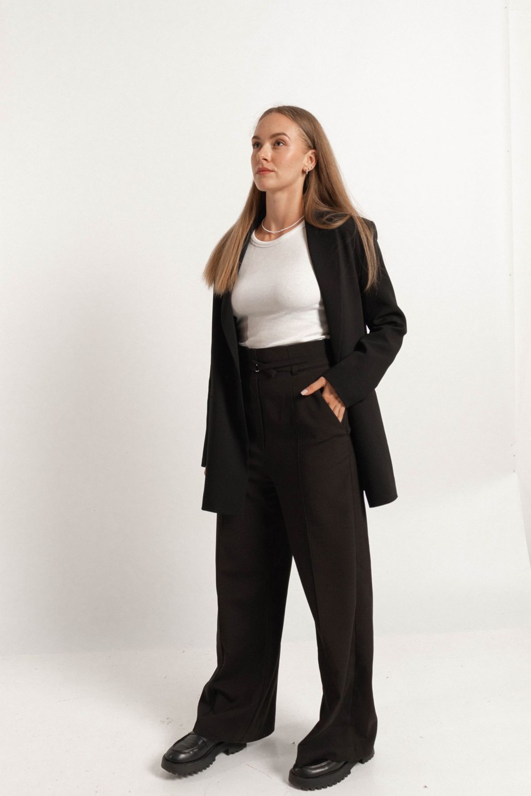 Long black blazer, white tank, black wide-leg trousers and chunky black shoes.