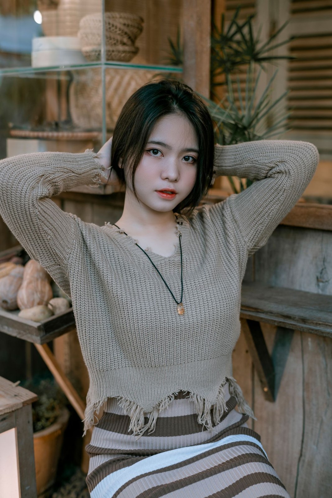 Taupe ribbed tie-front knit top and a striped skirt, cropped above the knees.