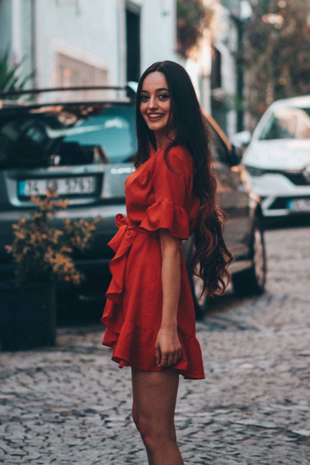 Short red puff-sleeve dress with a waist tie and a deep square neckline.