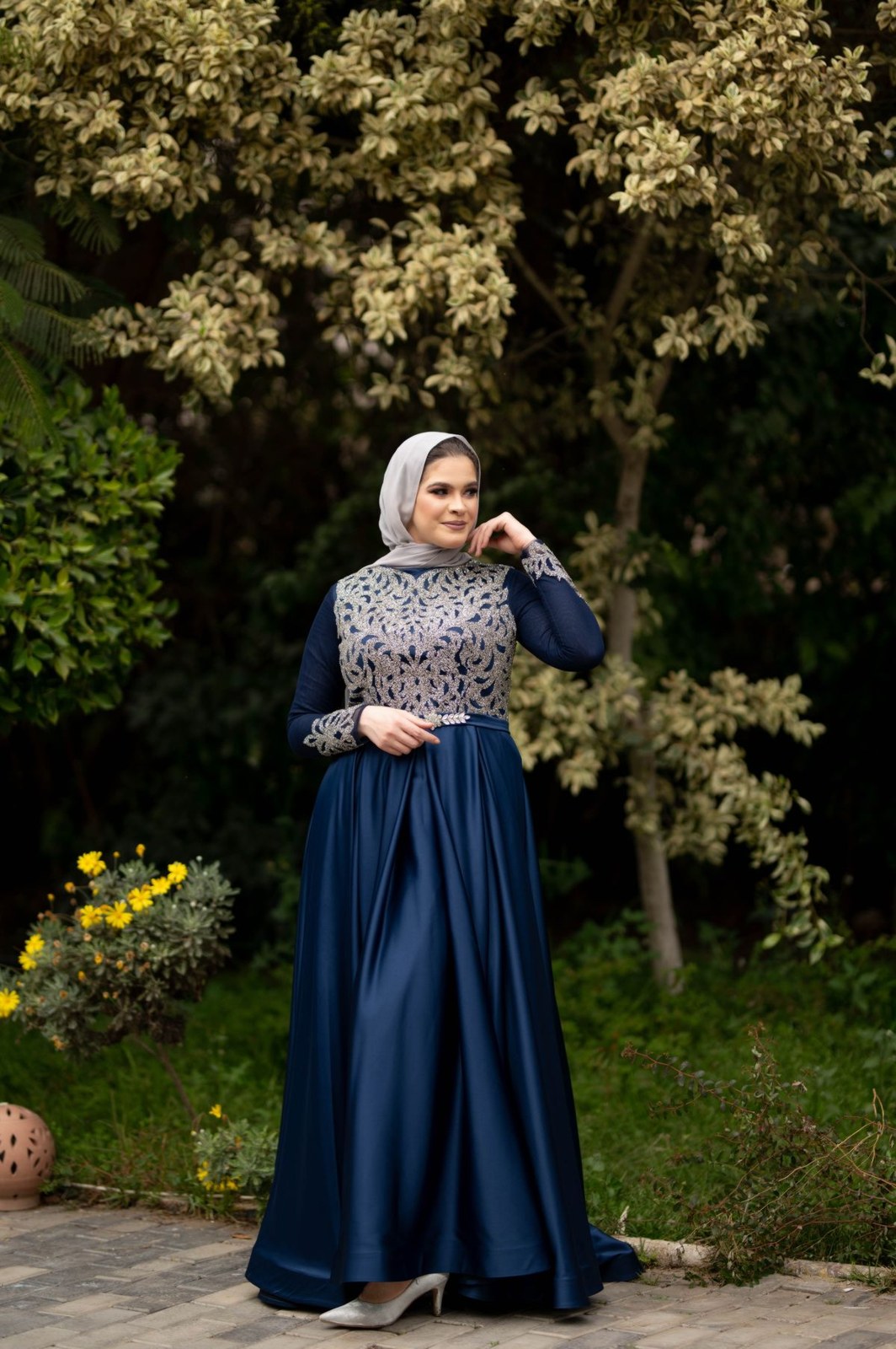 Long navy dress with patterned light front panel, navy sleeves and a light headscarf.
