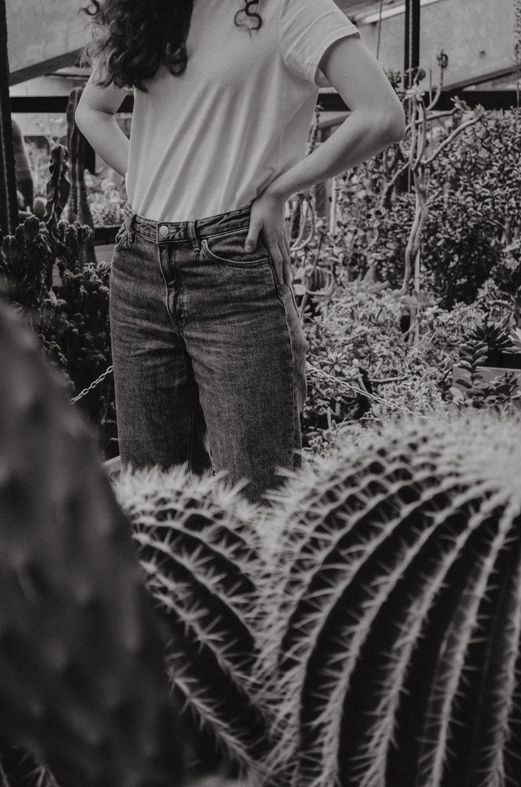 Black-and-white photograph of a loose light T-shirt tucked into jeans, cropped at the hip.