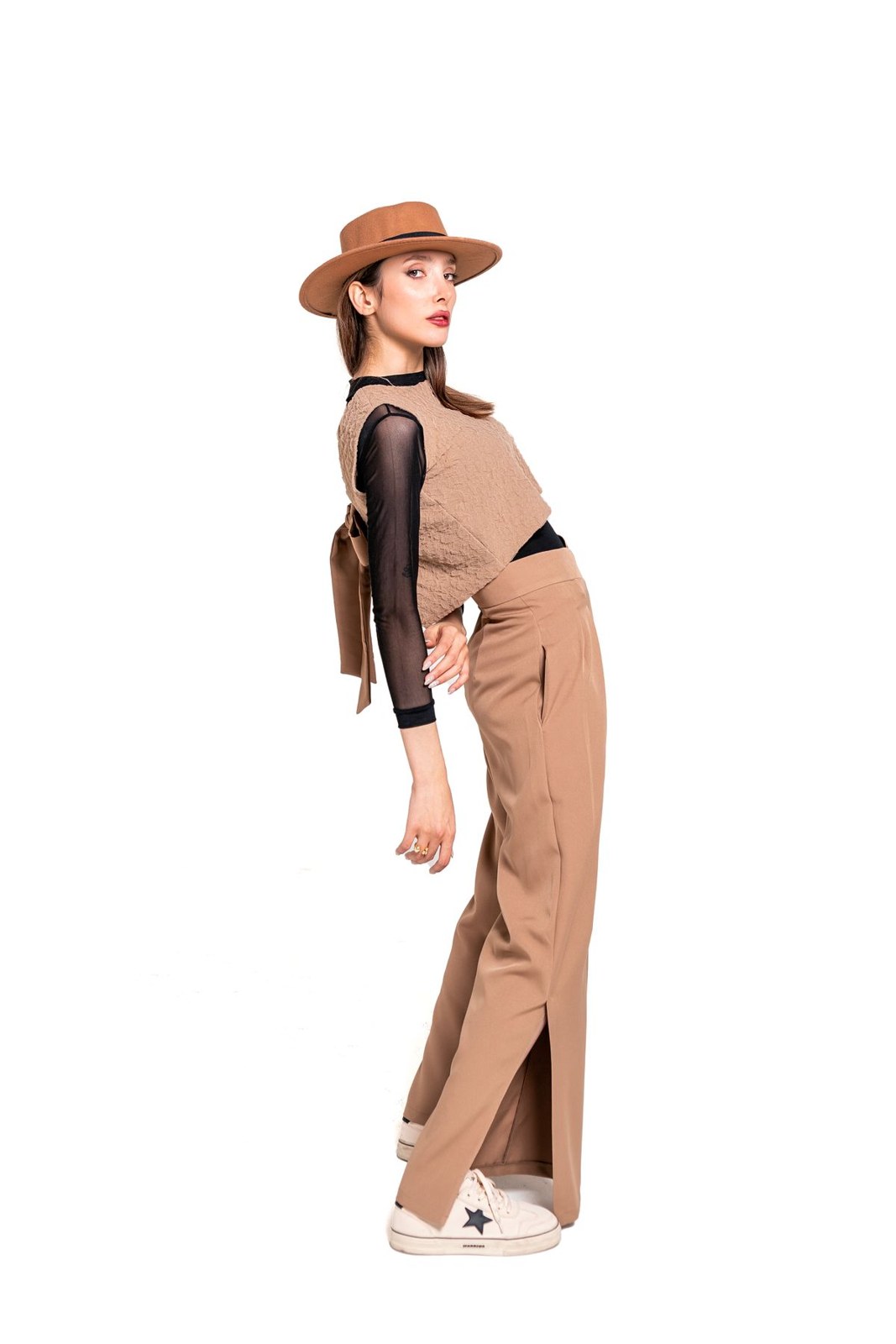 Tan sleeveless vest and matching wide trousers with a black top, brown hat and white trainers.