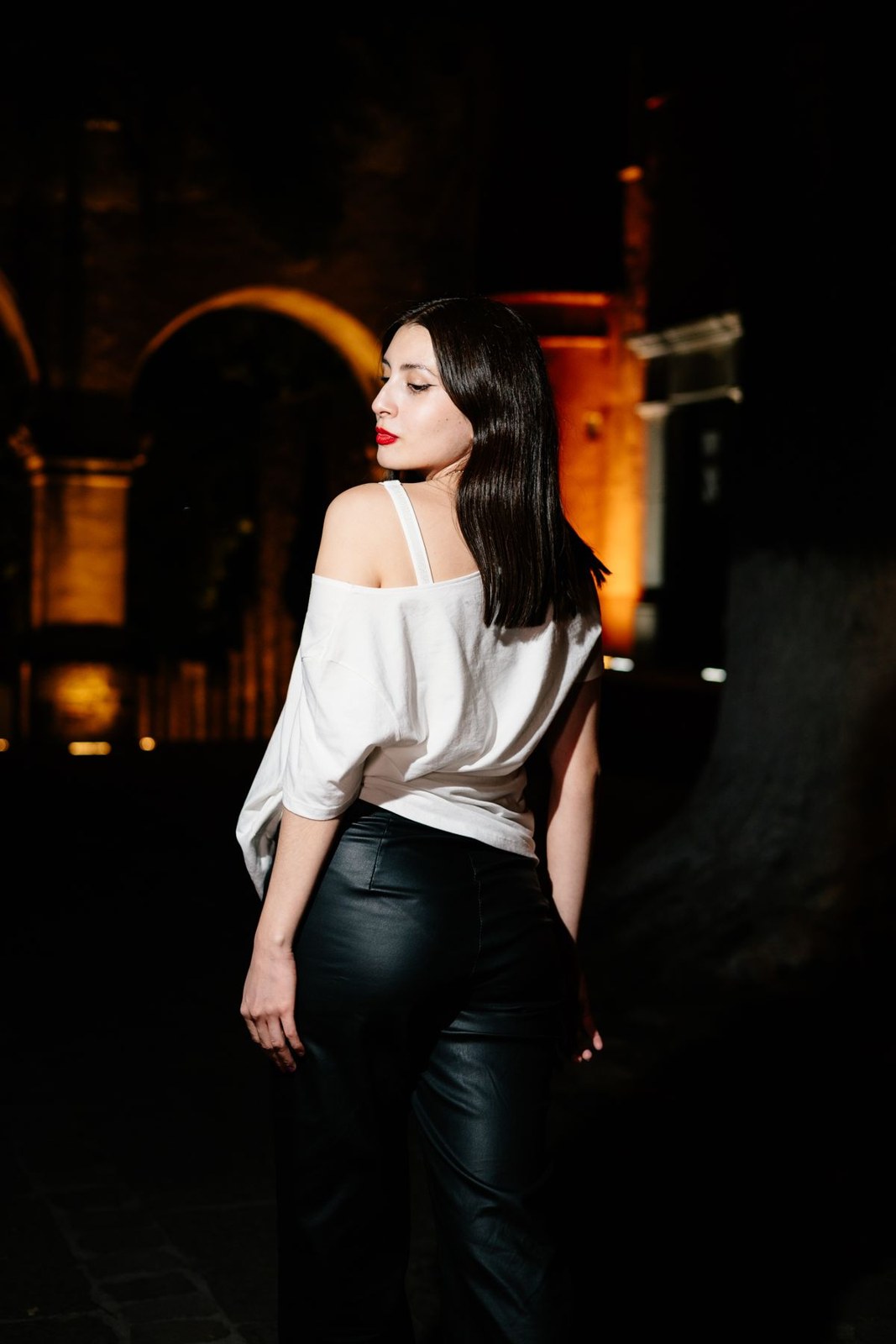White off-shoulder blouse and high-waisted black trousers in a rear three-quarter view.